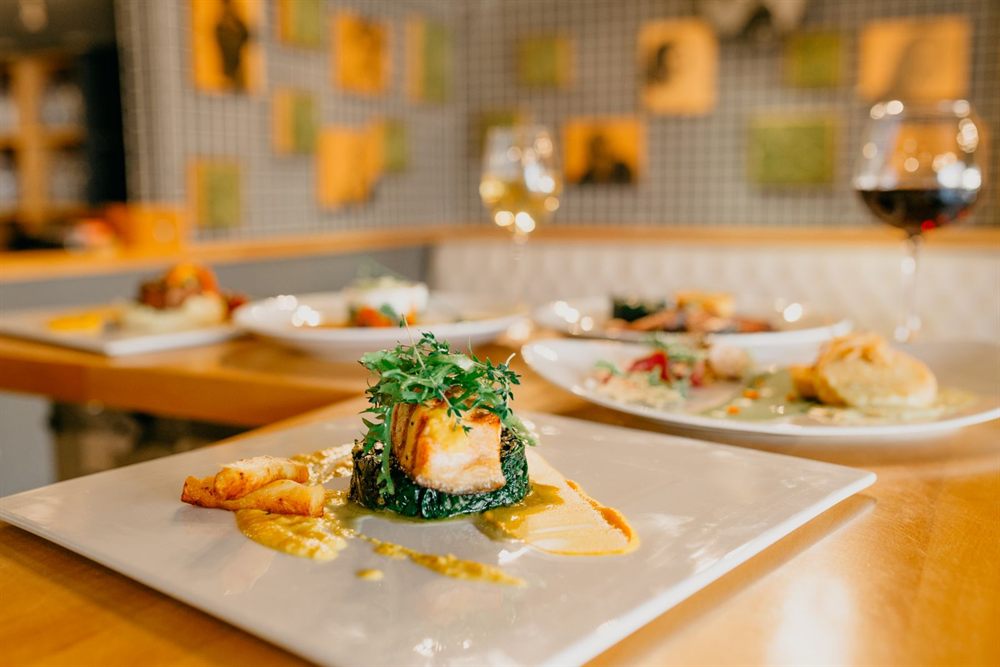 Plated gourmet dishes and glasses of wine on a restaurant table