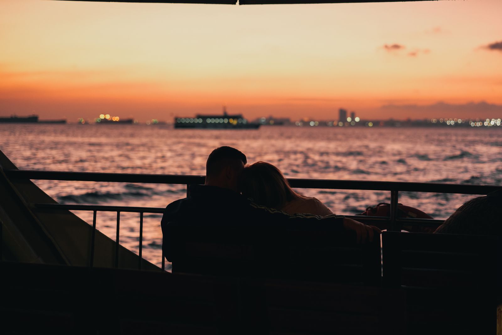 Couple silhouetted against a pink sunset over the sea, an image for the best cruise for couples