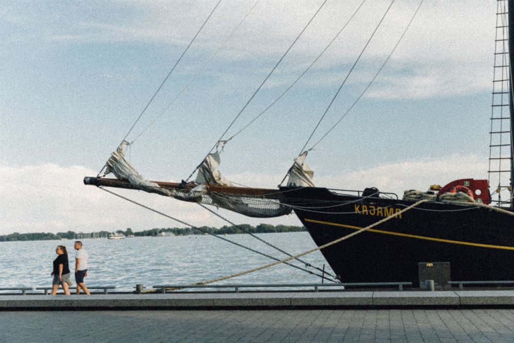 Bow and rigging of a tall sailing ship moored at a waterfront promenade