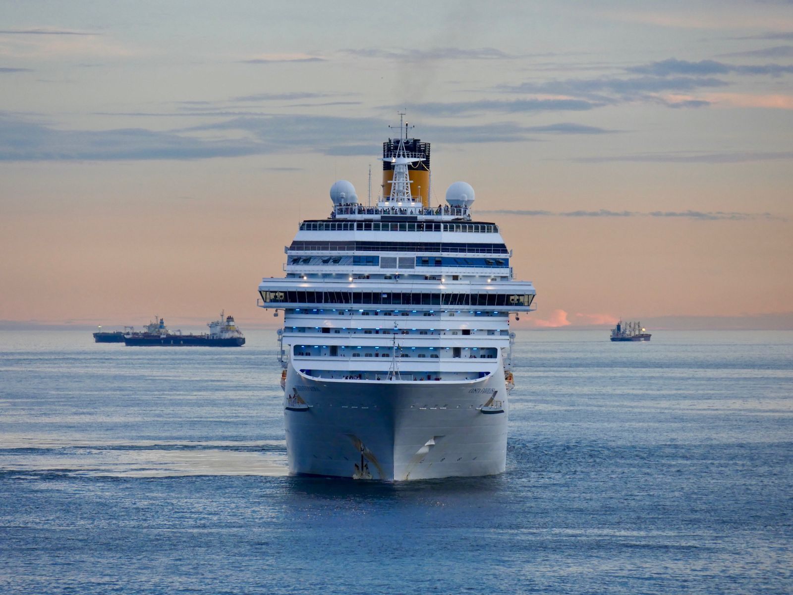 Cruise ship sailing toward the camera on a calm sea at dusk, one of many award winning cruises