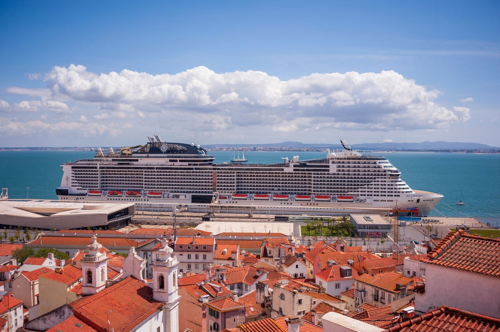 Cruise ship docked beyond the red rooftops of Lisbon, an award-winning cruise destination