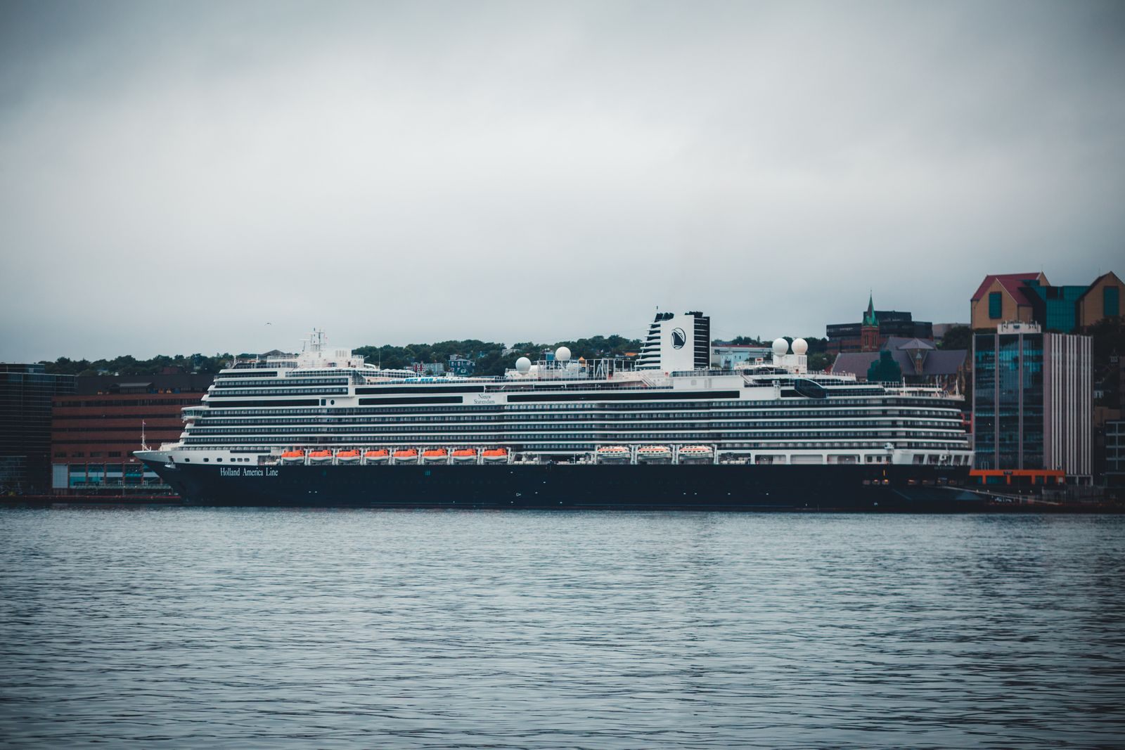 Award winning cruise ships come in every size: a large cruise ship docked at a city harbor