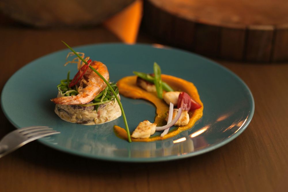 Shrimp and scallop starter plated on a blue dish